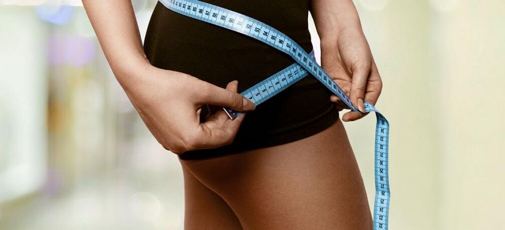 Eine Frau zeichnet die Ergebnisse einer effektiven Gewichtsabnahme auf. 